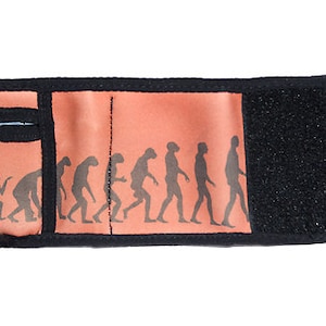 Puede incluir: Una cartera negra con cierre de velcro y un diseño rojo y negro con una silueta de la evolución de los humanos.