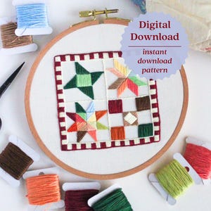 May include: A colorful embroidery hoop featuring a geometric quilt block design with star and square patterns. The design is stitched with green, orange, red, and brown threads. The text "Digital Download" is visible. Spools of thread in various colors surround the hoop.