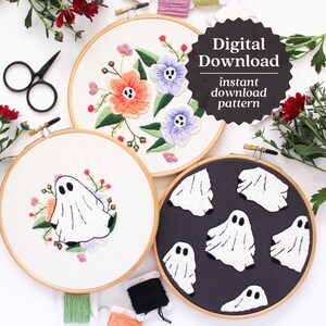 May include: Three embroidery hoops with different designs. The first hoop has a floral design with pink, orange, and blue flowers. The second hoop has a single white ghost with pink and purple flowers. The third hoop has a black background with multiple white ghosts. The text "Digital Download instant download pattern" is on a black circle.