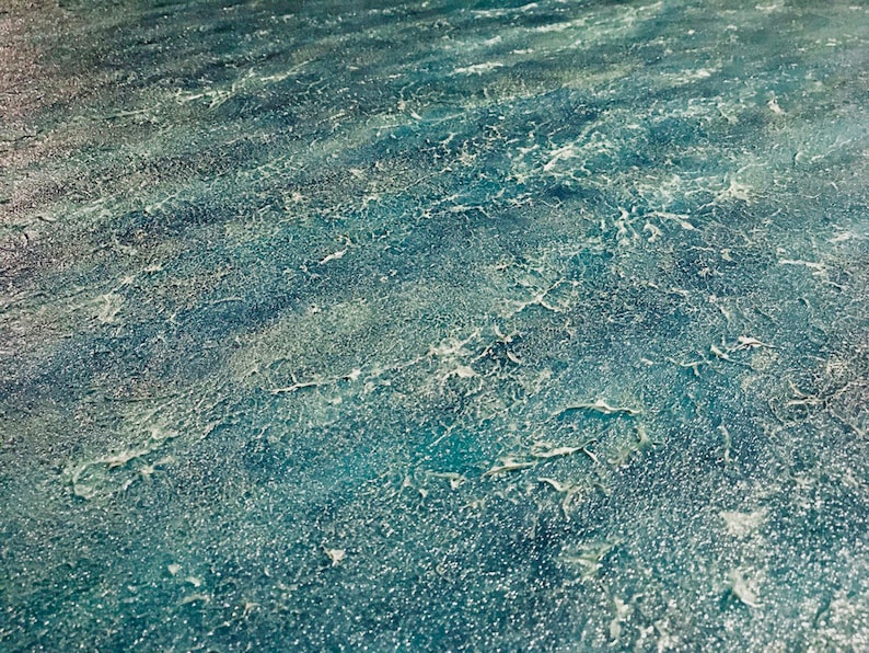 May include: A close-up of a textured blue surface with white accents. The surface has a rough, uneven texture, resembling a weathered or aged material.