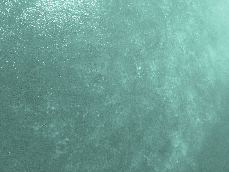 May include: A textured, teal green background with a subtle, light, speckled pattern.