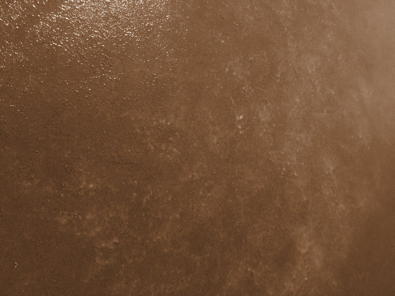 May include: A close-up of a brown textured surface with a subtle sheen. The surface has a slightly rough feel and appears to be made of concrete or a similar material.