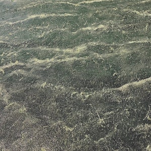 May include: A close-up of a textured surface with a green and yellow color scheme. The surface has a wavy pattern, resembling water.