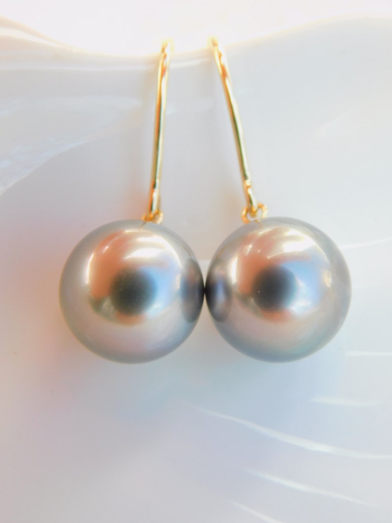 May include: A pair of silver pearl drop earrings with gold hooks.