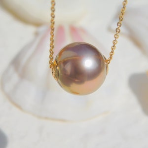 May include: A gold chain necklace with a large, round, iridescent pearl pendant.