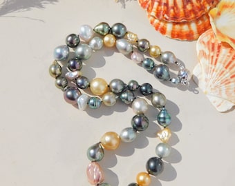 May include: A multi-strand pearl necklace with a variety of colors, including black, green, gold, and pink. The pearls are strung on a silver chain and have a baroque shape.