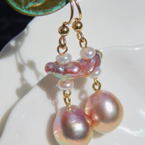 May include: Gold earrings with a cluster of pink and white pearls and two large pink pearl drops.