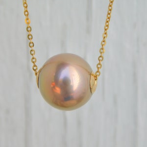 May include: A gold chain necklace with a large, round, iridescent pearl pendant.
