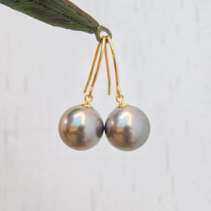 May include: A pair of gold dangle earrings with dark gray pearl drops.