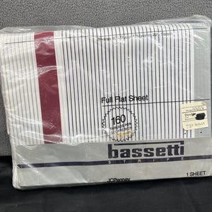 May include: A packaged full flat sheet with vertical navy and white stripes, and a burgundy stripe. The package reads "Full Flat Sheet" and "160 threads per square inch". The brand name "bassetti" is visible.