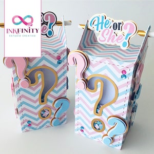May include: Two gender reveal boxes with a pink and blue chevron pattern. Each box has a large question mark cutout and smaller pink and blue question marks. The boxes are labelled "He or She?" on top.