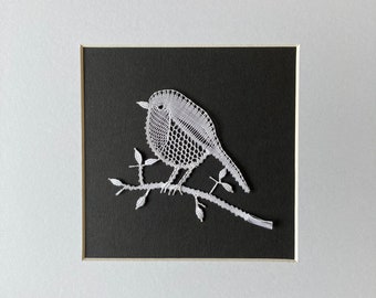 Poetic textile decoration to frame representing a robin made of bobbin lace in white cotton thread