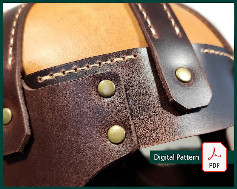 May include: Close-up of a brown leather helmet with a tan leather top. The helmet has decorative stitching and brass rivets.