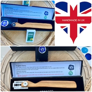 May include: A handmade English cherry wood razor handle in a black box, with a razor blade and a pack of Derby Extra blades. The box is labelled with text and a logo. The image includes a "HANDMADE IN UK" heart.