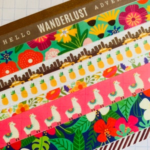 May include: A set of six colorful washi tapes with various patterns, including flowers, pineapples, llamas, and a cityscape. The tapes are labeled "Hello Wanderlust Adventure".