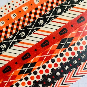 May include: Assortment of Halloween themed washi tapes with various patterns including ghosts, skulls, crossbones, coffins, polka dots, and chevron stripes in black, white, orange, and red.