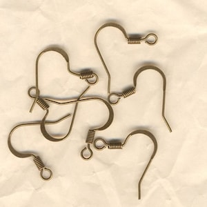 Peut inclure: Un ensemble de six crochets d'oreille dorés. Les crochets sont en métal et ont une fermeture à ressort.