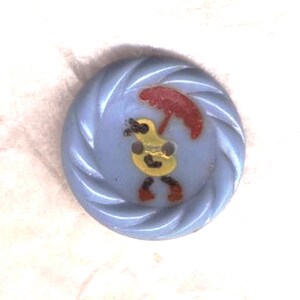 Peut inclure: Un bouton en plastique bleu avec un motif en spirale blanche. Un personnage de dessin animé jaune avec un parapluie rouge est imprimé sur le bouton.