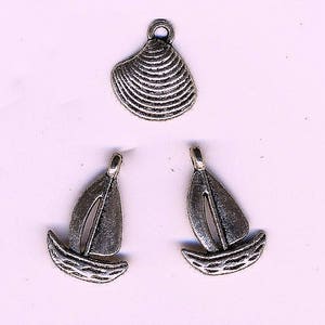 Peut inclure: Trois breloques en métal argenté : un coquillage et deux voiliers. Le charme du coquillage a une texture striée, et les voiliers ont un design détaillé. Ces breloques sont idéales pour la fabrication de bijoux ou les projets d'artisanat.