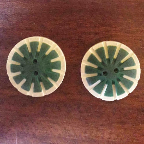 Two green sun or ray buttons, diameter 27 millimeters, sewing embellishment, vintage haberdashery, graphic style, 20th century