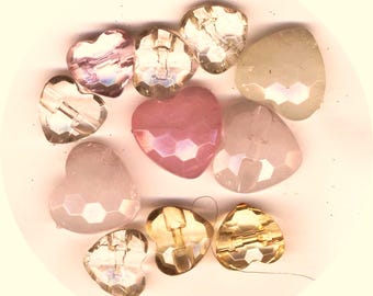 May include: Assortment of heart-shaped glass beads in various colors, including pink, clear, and white. The beads have a faceted design and are perfect for jewelry making or crafting.