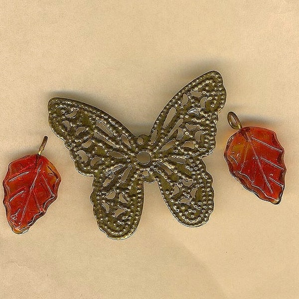 Filigrane papillon bronze et feuilles rouges, trois breloques de métal et verre pour création de bijoux fantaisie