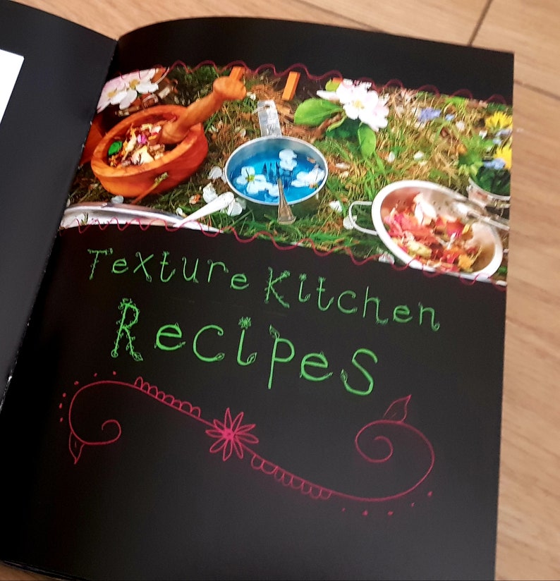 Puede incluir: Un libro negro con el t&iacute;tulo "Texture Kitchen Recipes" escrito en verde y rosa en la portada. La portada presenta una foto de un cuenco de madera, cuencos de metal y flores sobre un lecho de hierba verde.