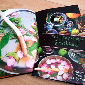 Puede incluir: Un libro cerrado con una cubierta negra y el t&iacute;tulo "Texture Kitchen Recipes" en texto blanco. La cubierta presenta un collage de im&aacute;genes de comida y naturaleza. El libro es de "Naturally Creative Early Years".