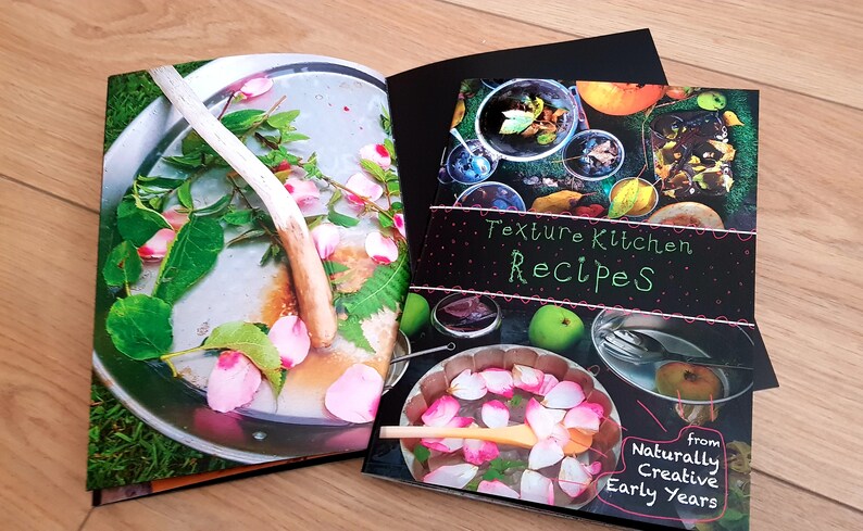 Puede incluir: Un libro cerrado con una cubierta negra y el t&iacute;tulo "Texture Kitchen Recipes" en texto blanco. La cubierta presenta un collage de im&aacute;genes de comida y naturaleza. El libro es de "Naturally Creative Early Years".