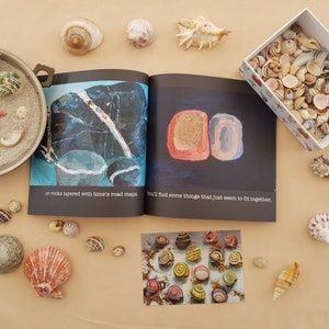 May include: A collection of seashells in various shapes, sizes, and colors, including a small bowl filled with sand and seashells, a box of seashells, and a book with the text "You'll find some things that just seem to fit together."