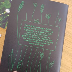 Puede incluir: Fondo negro con texto verde escrito a mano que dice "Desde tartas de barro hasta pociones m&aacute;gicas, la naturaleza proporciona una abundancia de ingredientes para que los ni&ntilde;os creen recetas en una cocina de barro. Explora y busca gratis en un jard&iacute;n, parque, playa o bosque y usa barro, arena y los tesoros de la naturaleza para desbloquear maravillosas recetas para un juego imaginativo."