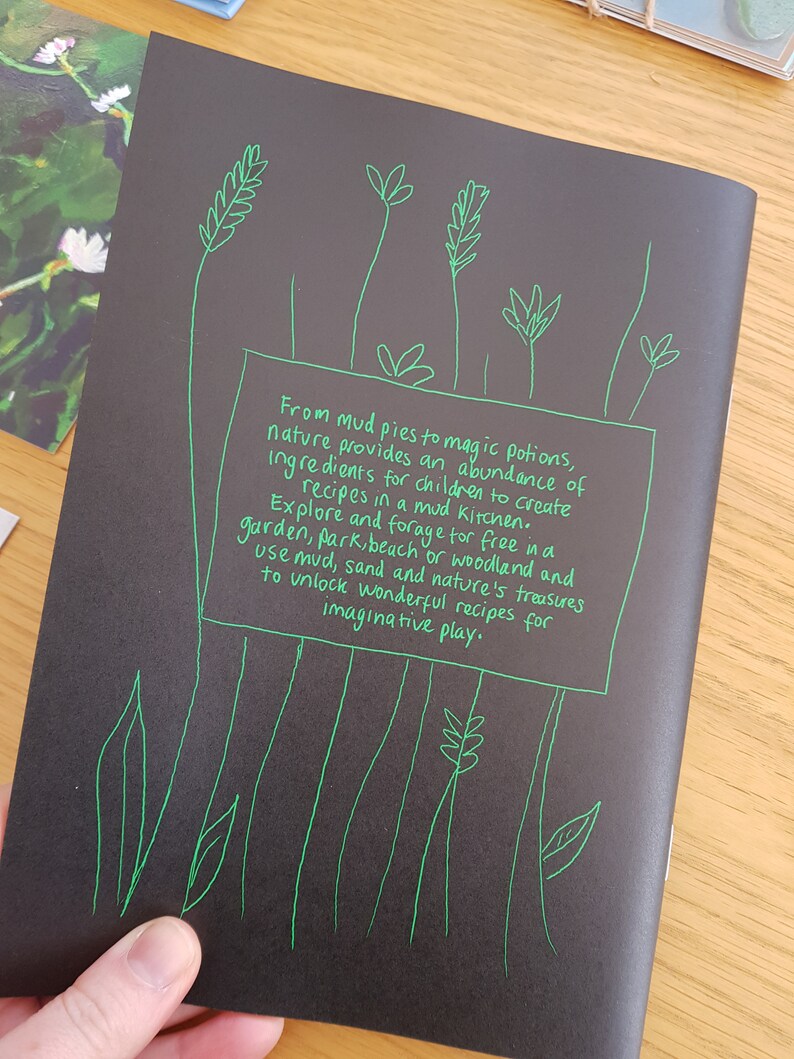 Puede incluir: Fondo negro con texto verde escrito a mano que dice "Desde tartas de barro hasta pociones m&aacute;gicas, la naturaleza proporciona una abundancia de ingredientes para que los ni&ntilde;os creen recetas en una cocina de barro. Explora y busca gratis en un jard&iacute;n, parque, playa o bosque y usa barro, arena y los tesoros de la naturaleza para desbloquear maravillosas recetas para un juego imaginativo."