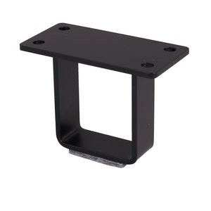 May include: Black metal furniture leg with a square base and a rectangular top plate. The leg has four pre-drilled holes for mounting and a gray felt pad on the bottom.