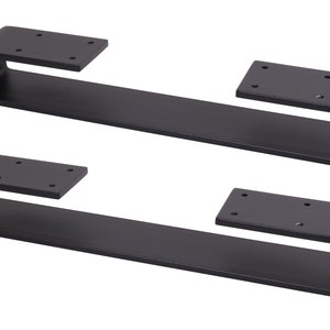 May include: Two black metal shelf brackets with a curved design. Each bracket has a flat top plate with four holes for mounting.