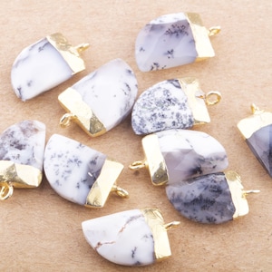 May include: A collection of eight white and gray agate gemstone pendants with gold accents. Each pendant is shaped like a half-moon and has a gold bail for attaching to a necklace or bracelet.