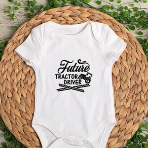 May include: White baby onesie with black text that reads "Future Tractor Driver" and a small black tractor graphic.