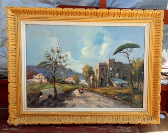 Puede incluir: Una pintura al óleo enmarcada que representa un paisaje rural italiano con un camino de tierra que conduce a un pequeño pueblo. La pintura presenta un cielo azul con nubes blancas, árboles verdes y un edificio de piedra con un techo rojo.