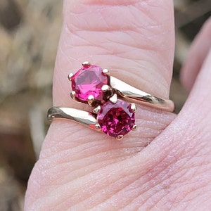 Peut inclure: Une bague en or avec deux pierres précieuses roses serties dans une bande torsadée.
