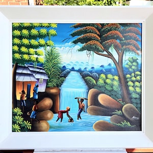 Rara pintura al óleo haitiana de los años 80 con figuras y un paisaje de cascada azul de ensueño firmada con marco blanco pintado vintage. Bonita apariencia. VER VIDEO