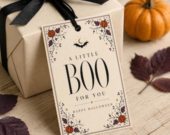 Peut inclure: Une étiquette cadeau rectangulaire de couleur crème avec le texte A LITTLE BOO FOR YOU et HAPPY HALLOWEEN en noir. Le motif comprend des illustrations de citrouilles orange, de feuilles violet foncé, d'étoiles, d'un croissant de lune et d'une chauve-souris noire.