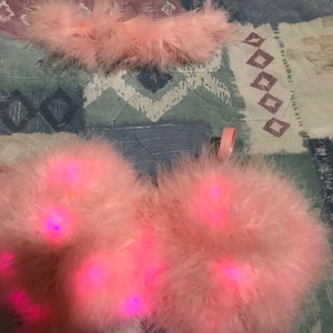 May include: Two pink fluffy wings with pink lights, and a pink fluffy headband.