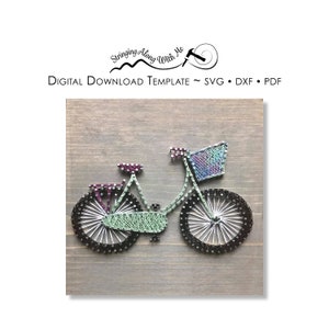 May include: A green bicycle with a basket on the handlebars, made with string art on a wood background. The bicycle has black wheels and a purple seat.