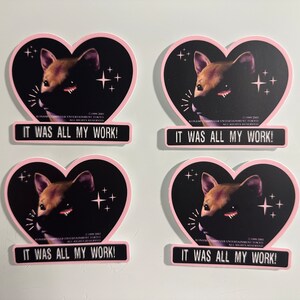 May include: Four stickers with a heart shape and a pink border. Each sticker features a brown dog illustration against a black background with the text "IT WAS ALL MY WORK!". The stickers have a retro aesthetic.