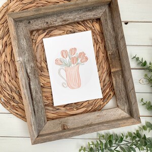 May include: A watercolor painting of a pink pitcher filled with a bouquet of peach-colored tulips. The pitcher has a delicate, swirling handle and sits on a white background.