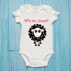May include: White baby onesie with a black sheep illustration and the text "Who me...baaad?" in pink.