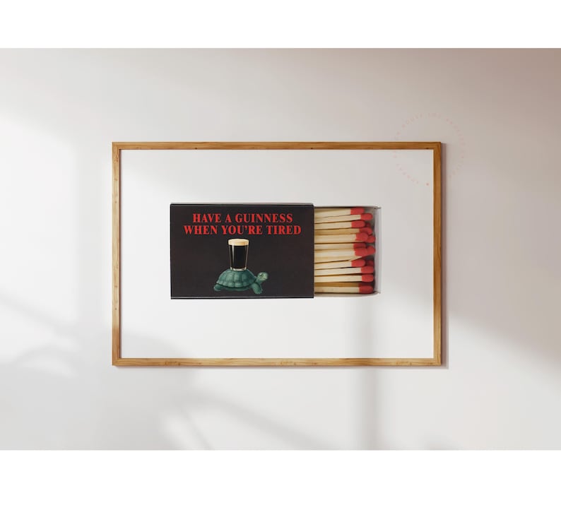 May include: A framed matchbox art piece. The matchbox is black with the text "HAVE A GUINNESS WHEN YOU'RE TIRED" in red. A cartoon turtle holds a pint of Guinness. The matches have red tips.
