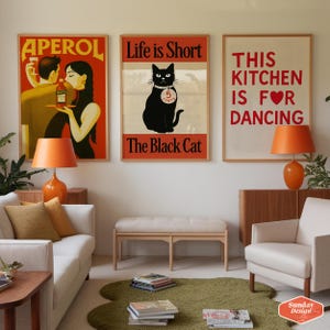 May include: Three framed posters with different designs. The first poster is a vintage advertisement for Aperol featuring a man and woman. The second poster features a black cat with the text "Life is Short, The Black Cat". The third poster has the text "This Kitchen is for Dancing" with a red heart.