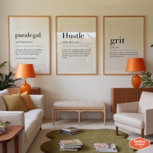 Puede incluir: Tres impresiones enmarcadas con fondos blancos y texto negro. Las impresiones se titulan "Paralegal", "Hustle" y "Grit". Las impresiones est&aacute;n colgadas en una pared en una sala de estar con un sof&aacute; blanco, un banco de madera y un sill&oacute;n blanco.