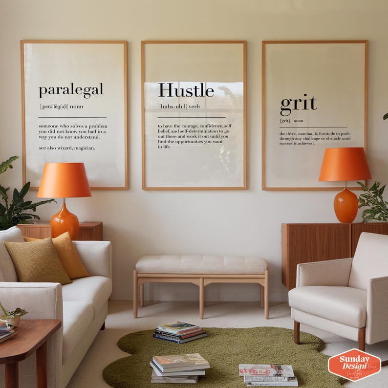 Puede incluir: Tres impresiones enmarcadas con fondos blancos y texto negro. Las impresiones se titulan "Paralegal", "Hustle" y "Grit". Las impresiones est&aacute;n colgadas en una pared en una sala de estar con un sof&aacute; blanco, un banco de madera y un sill&oacute;n blanco.