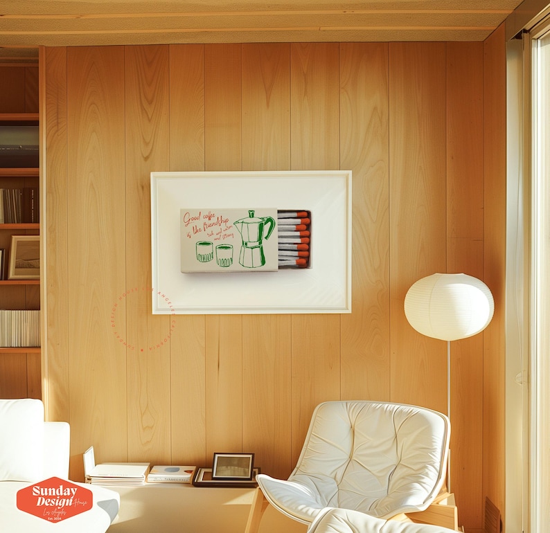 May include: A framed print of a matchbox with a green illustration of a coffee pot and two cups. The text on the matchbox reads "Good coffee is the friendship that lasts forever".